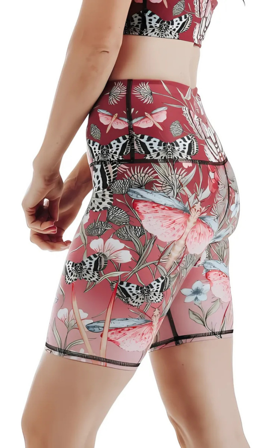 Butterfly and floral patterned shorts on a plain background